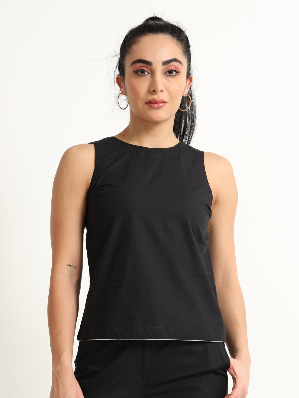 Organic Black cotton Closed neck sleeveless top with white piping detailing at the hem line.