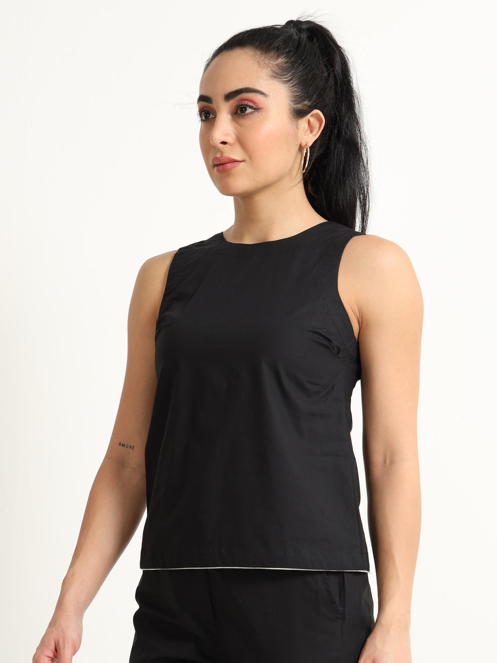 Organic Black cotton Closed neck sleeveless top with white piping detailing at the hem line.