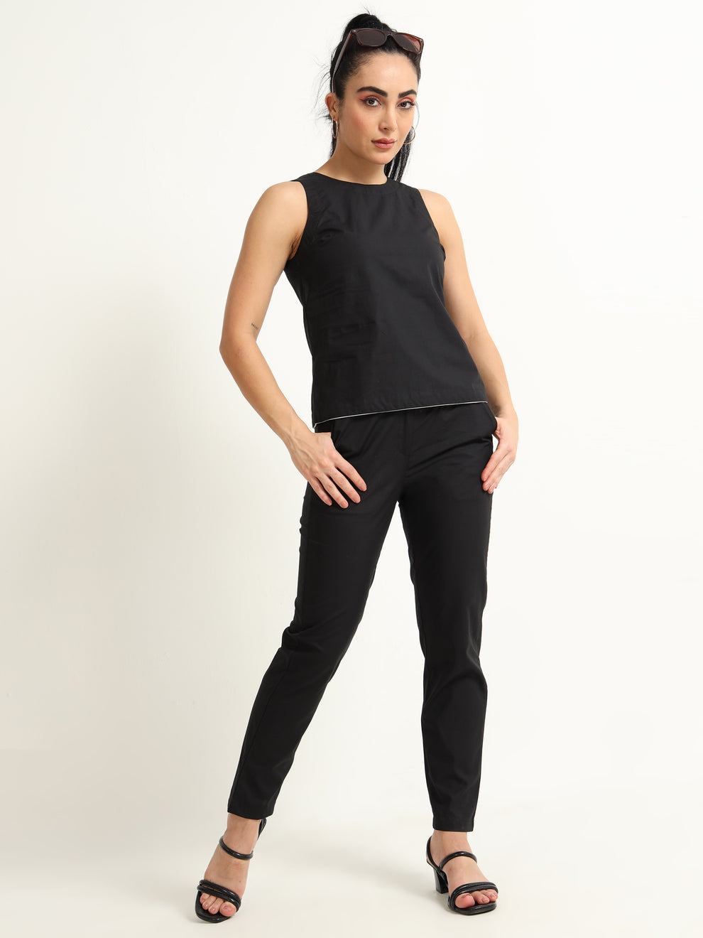 Organic Black cotton Closed neck sleeveless top with white piping detailing at the hem line.